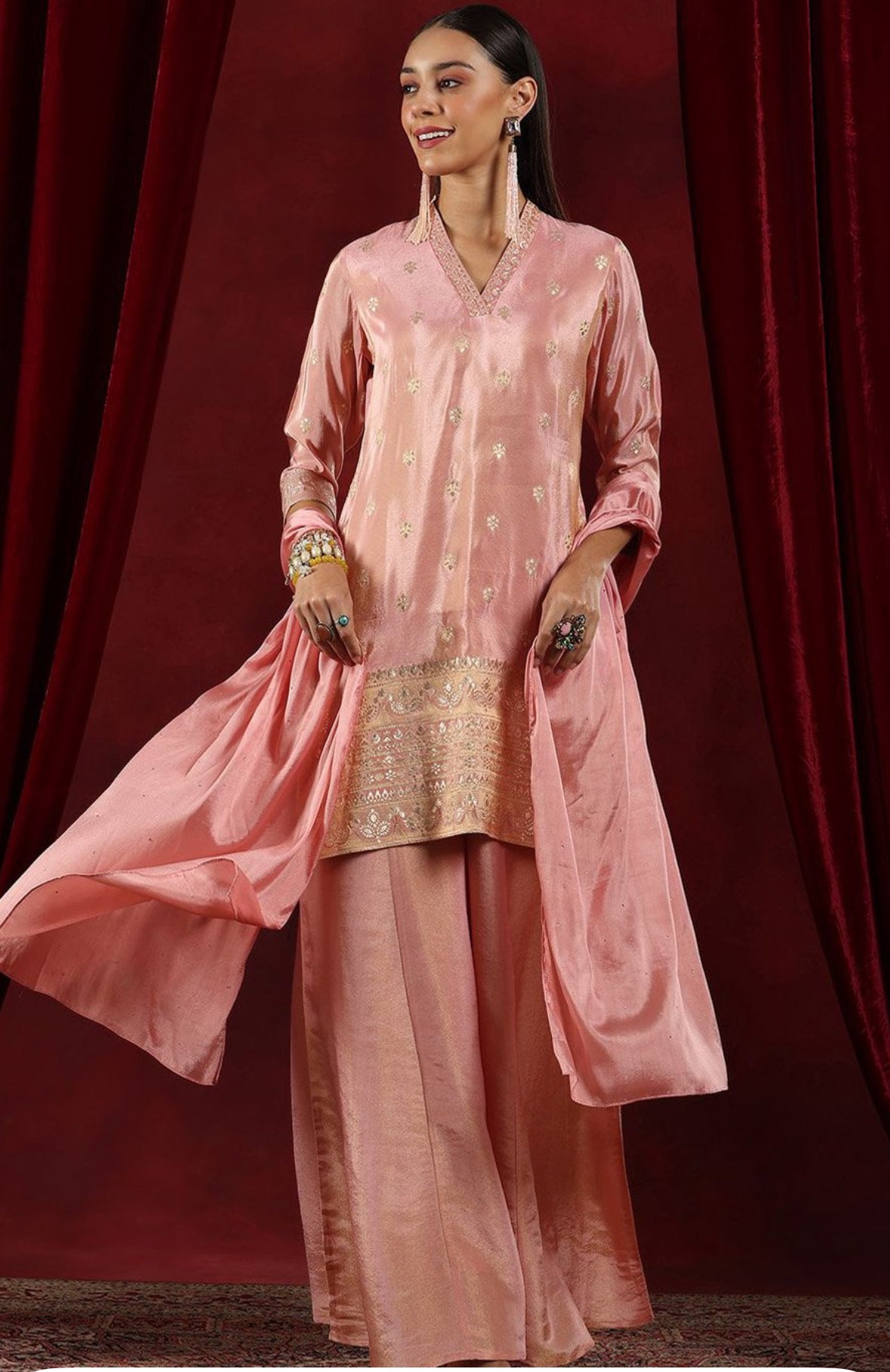 Bright pink ethnic Sharara outfit with heavy detailing and matching dupatta, suitable for traditional events.